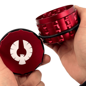 close-up of a red 4 piece large flat top herb grinder held in hand, showcasing premium design and craftsmanship.